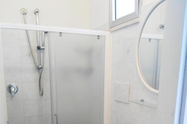 Bagno piccolo con doccia, lavandino e WC.