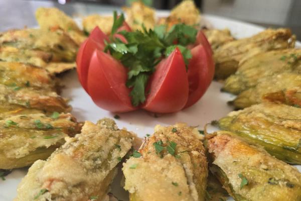 Fiori di zucca fritti con decorazione di pomodoro.