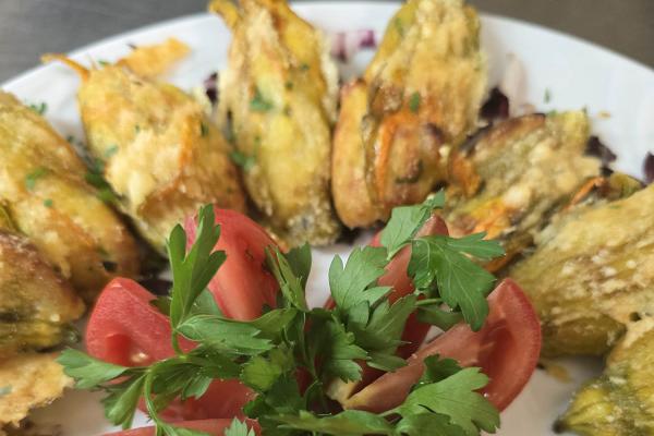 Fiori di zucca fritti con pomodori e prezzemolo.