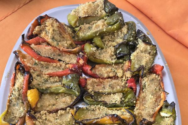 Peperoni ripieni di pangrattato su piatto bianco.