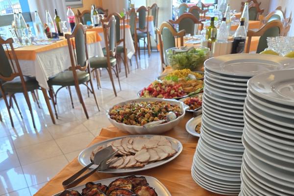 Buffet con piatti vari, insalate, carne e anelli di cipolla.