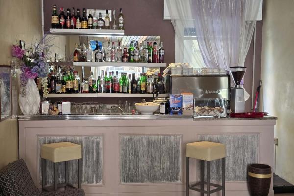 Un elegante bar con bottiglie colorate e atmosfera raffinata.