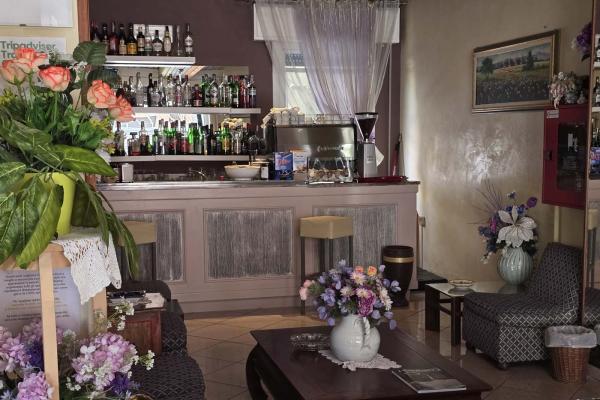 Accogliente bar con fiori colorati e atmosfera rilassante.