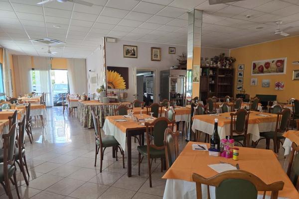 Ristorante accogliente con tavoli apparecchiati e decorazioni floreali.