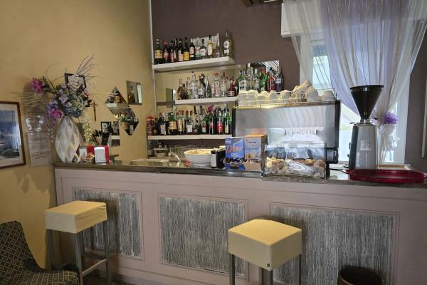 Accogliente bar con caffè, liquori e dolci, atmosfera calda e invitante.