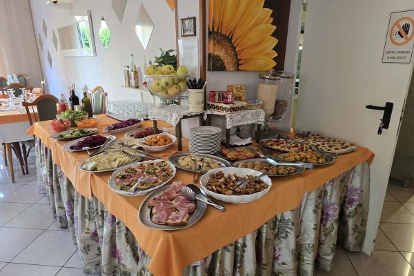 Ricco buffet colorato, piatti deliziosi, atmosfera accogliente e calda.