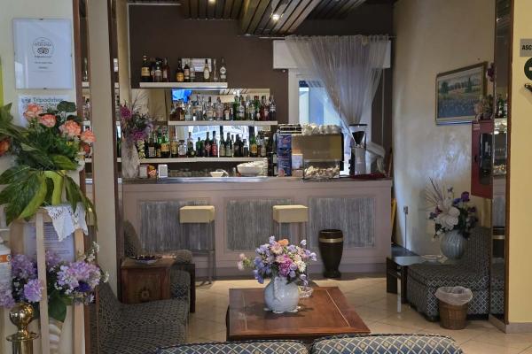 Accogliente bar vintage con fiori colorati e sedie eleganti.
