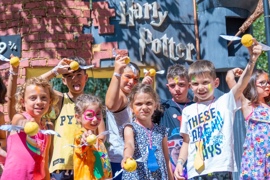 Lächelnde Kinder mit goldenen Flügeln, magische Harry-Potter-Atmosphäre.
