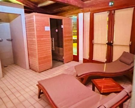 Espace détente avec sauna et chaises longues en bois.