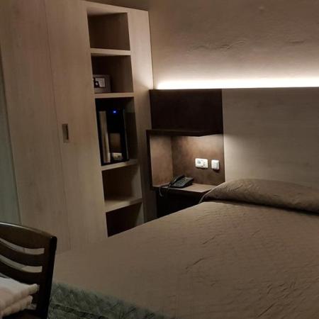 Modern room with double bed and soft lighting.