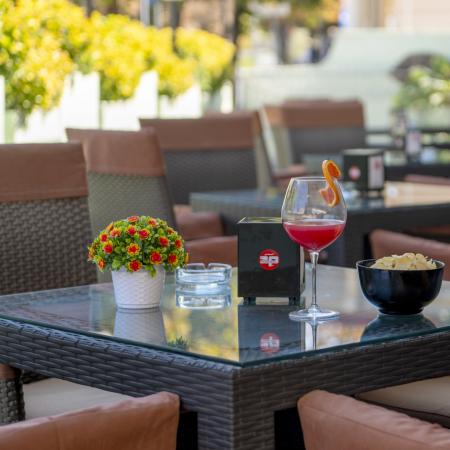 Outdoor table with drink, chips, and floral decorations.