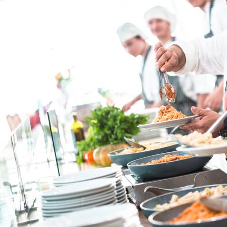 Chef servono pasta con passione in un buffet elegante e vivace.