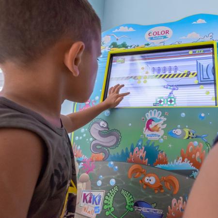 Bambini giocano felici a un colorato videogioco interattivo.
