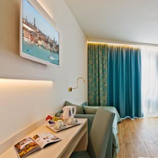 Modern hotel room with blue decor and elegant furnishings.