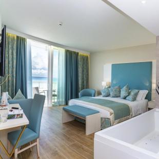 Modern room with sea view, bathtub, and floral decor.