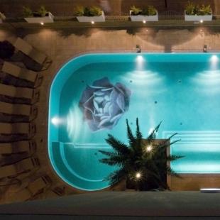 Illuminated pool with floral design viewed from above.