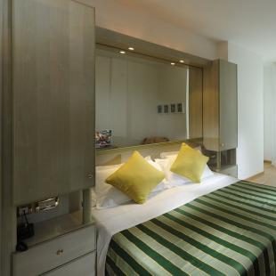 Modern room with bed, TV, and wall decorations.