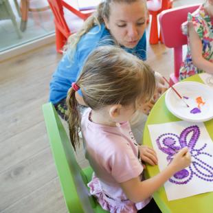 Children painting butterflies with bright colors in an art class.