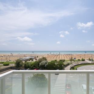 Sea view with beach, umbrellas, and clear sky.