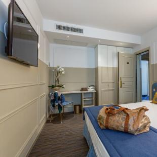 Modern hotel room with bed and stylish decor.