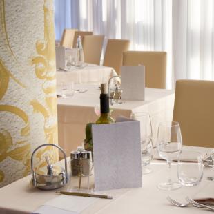 Elegant restaurant with set tables and natural light.