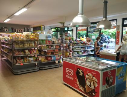 Un negozio vivace con scaffali pieni di snack e un banco gelati.