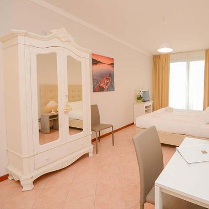 Bright bedroom with elegant furniture and flowers on the table.