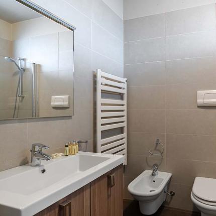 Bagno moderno con doccia, lavabo, bidet e WC.