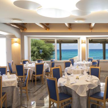 Ristorante elegante con vista mare, arredamento moderno e luminoso.