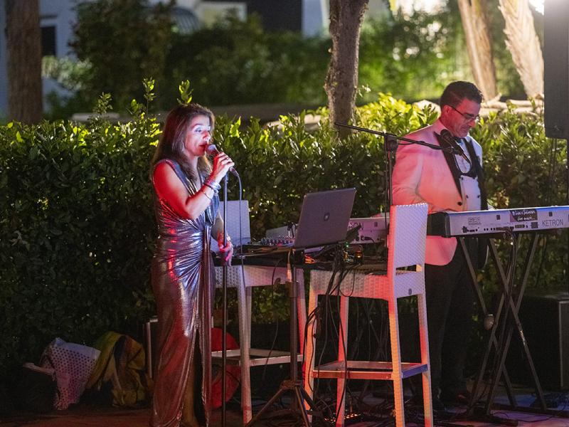 Cantante e tastierista si esibiscono all'aperto di notte.