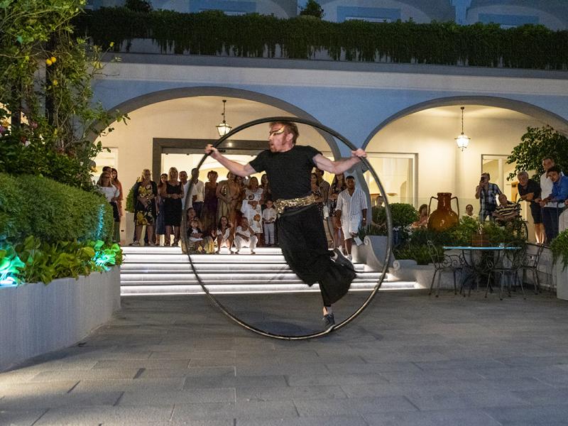 Artista con ruota davanti a spettatori in una villa.