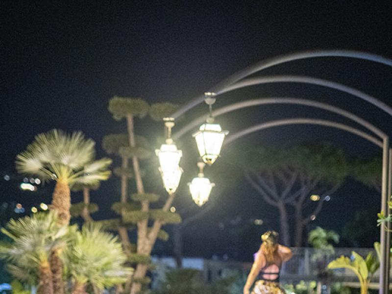 Evento notturno con artisti in costumi stravaganti e luci brillanti.