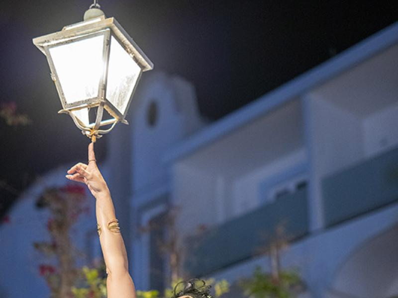 Donna elegante sotto un lampione, di notte.