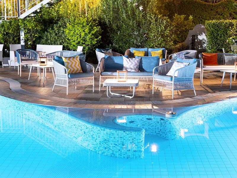 Area relax con piscina e sedute colorate all'aperto.