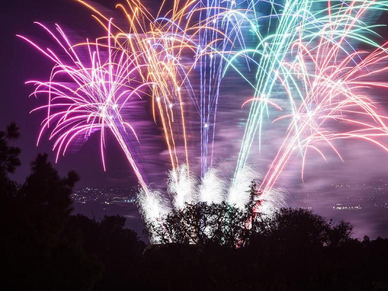 Fuochi d'artificio colorati illuminano il cielo notturno sopra la città.