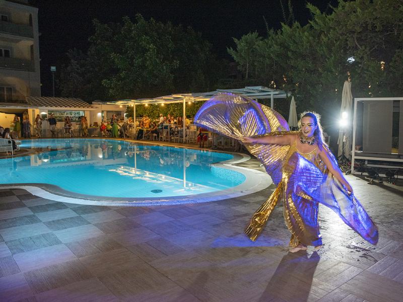 Spettacolo di danza in piscina con costumi dorati di notte.