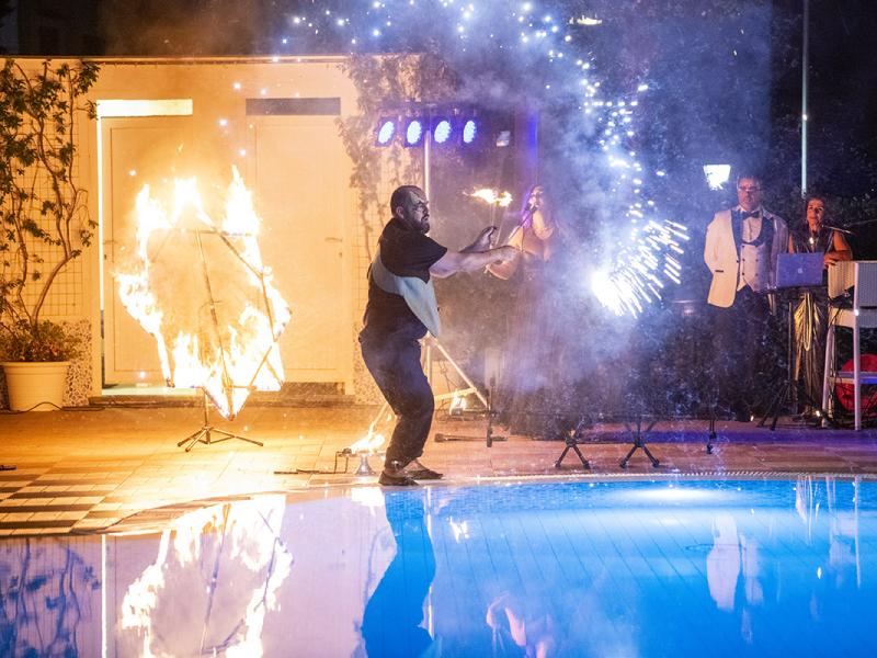 Spettacolo di fuoco e musica accanto alla piscina di notte.