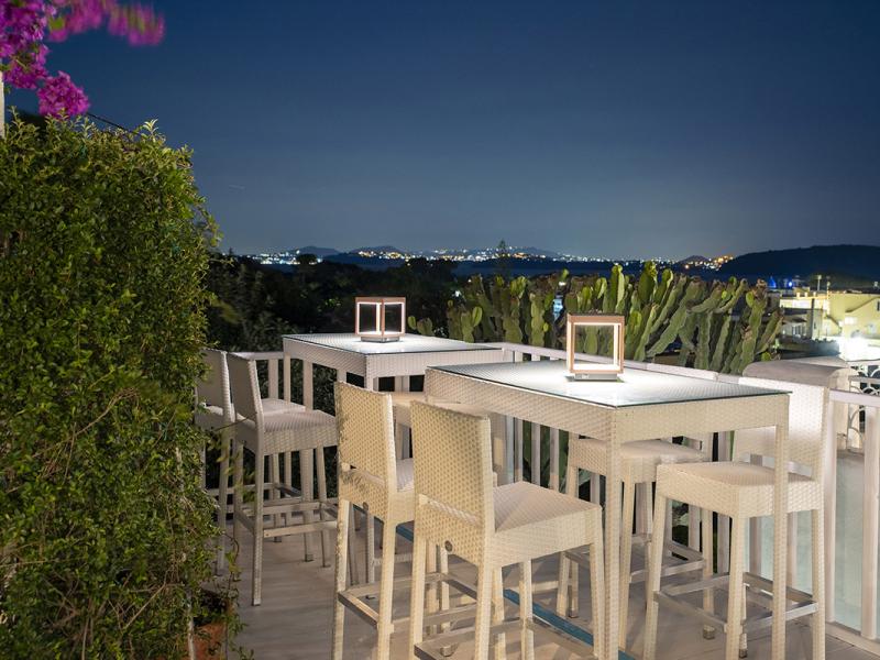 Night terrace with white tables and panoramic view.
