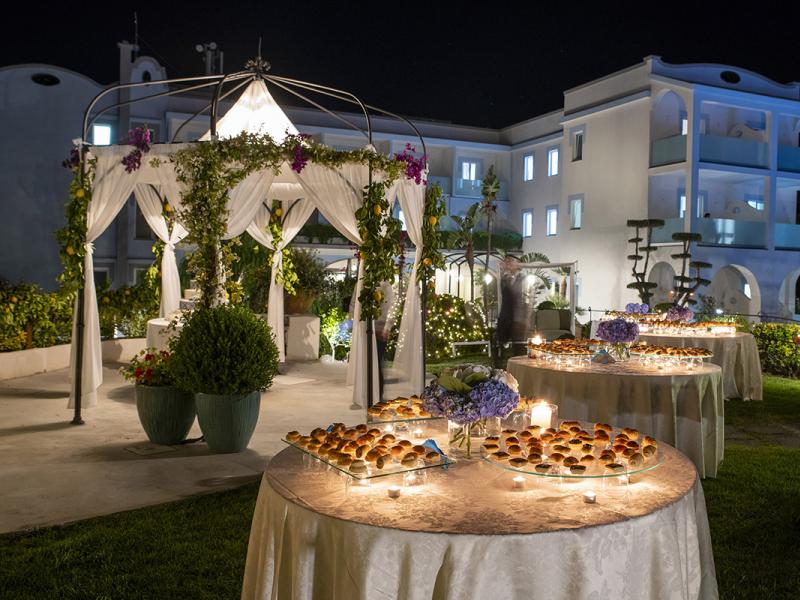 Night garden with gazebo, decorated tables, and soft lights.