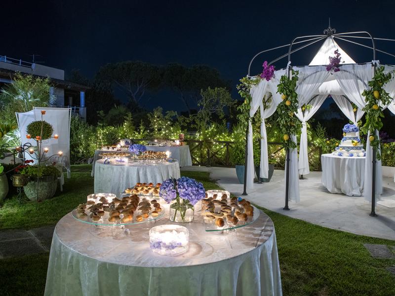 Elegant outdoor reception with decorated gazebo and set tables.