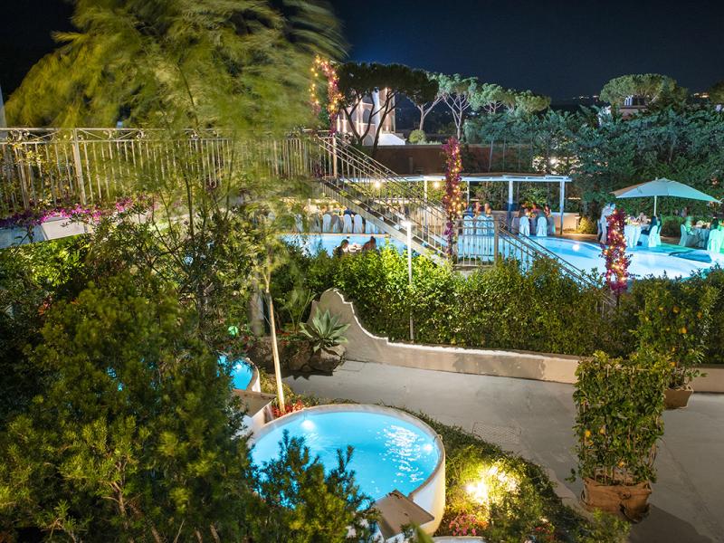 Night garden with pool and lights, elegant and relaxing atmosphere.