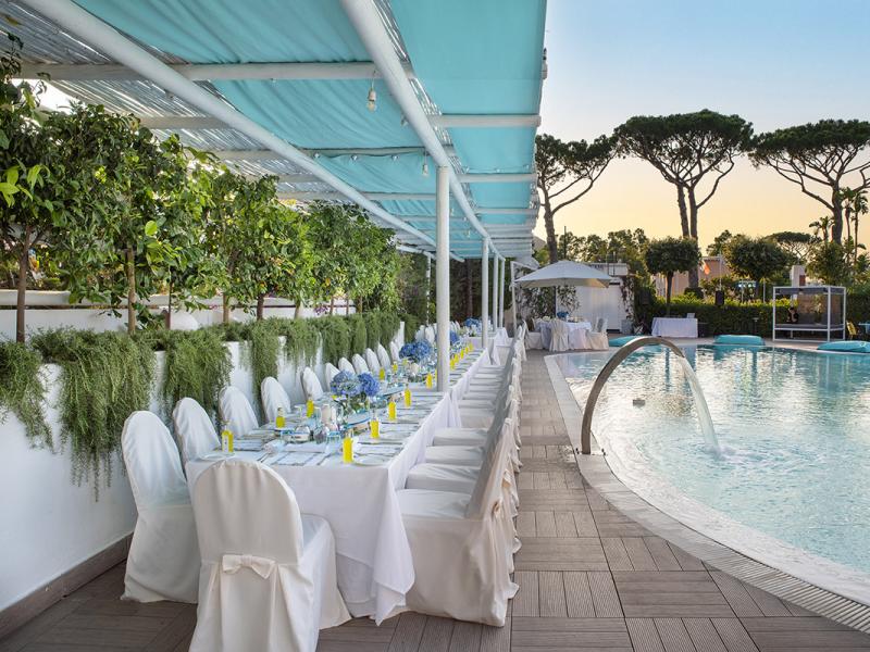 Elegant poolside dinner with floral decorations.