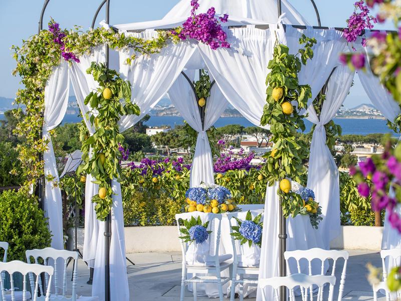 Gazebo adorned with lemons and flowers, sea view.