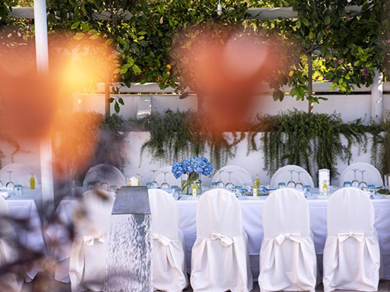 Poolside table setup with white chairs, elegant atmosphere.