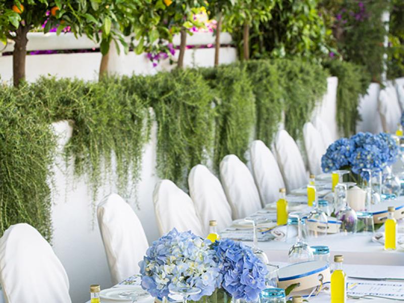 Elegant table with blue flowers and yellow bottles.