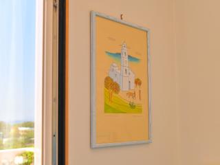 Quadro colorato di una chiesa con paesaggio sereno e alberi.