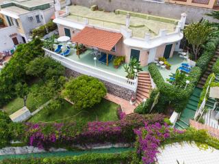 Villa mediterranea con giardino fiorito, terrazza e vista rilassante.