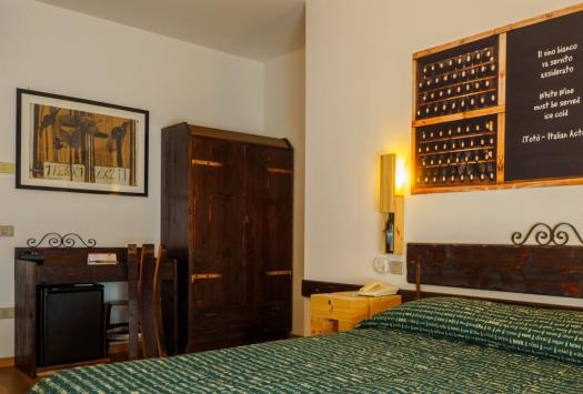 Gemütliches Zimmer mit rustikalen Möbeln und einem Wein-Zitat.