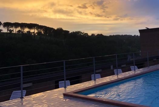 Pool bei Sonnenuntergang, goldener Himmel, ruhige Atmosphäre.