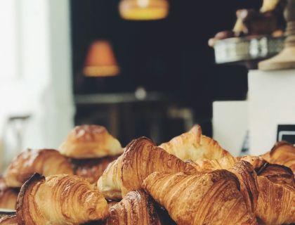 Deliziosi croissant dorati in una calda atmosfera da caffetteria.